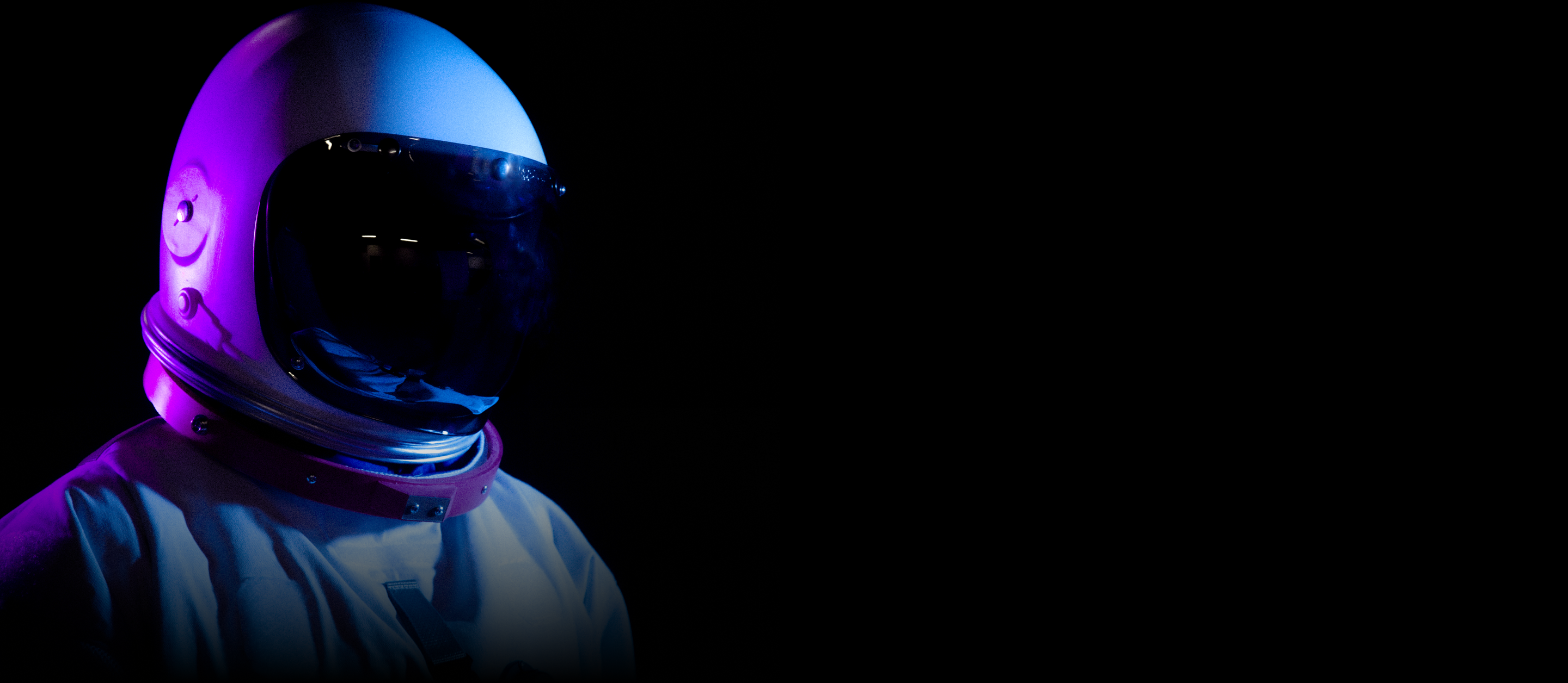 An astronaut's helmet on a black background.