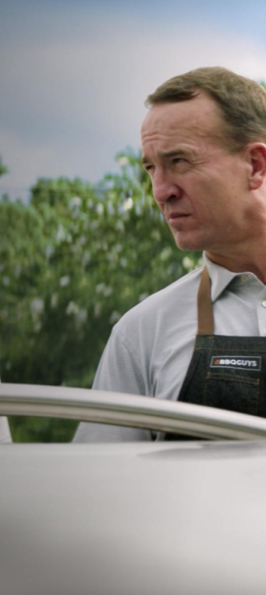 Peyton Manning overlooking a grill.