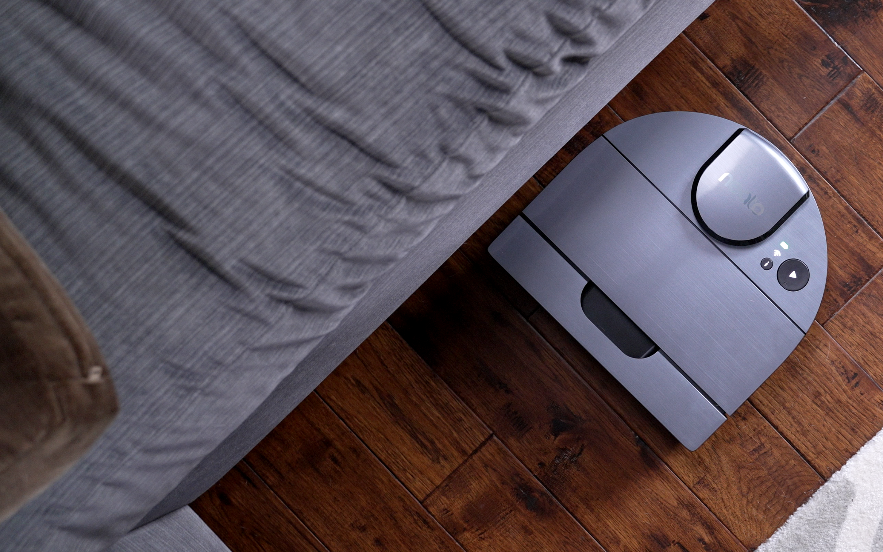 A Neato Robotics robot vacuum on hardwood flooring.