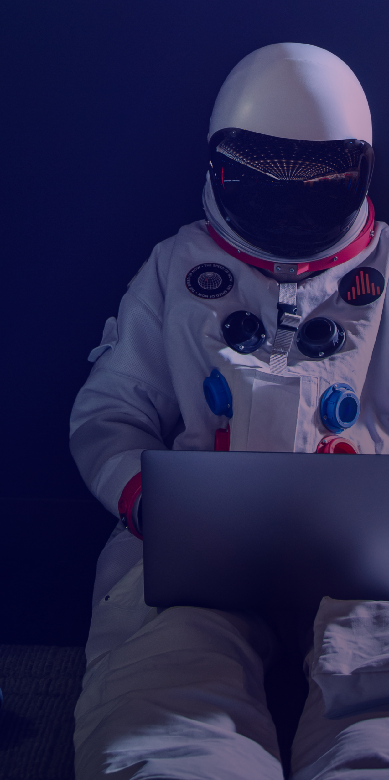 An astronaut working on a laptop.