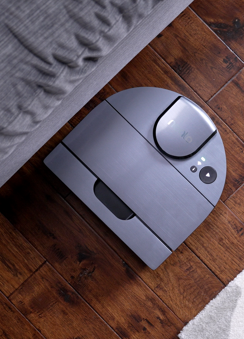 A Neato Robotics robot vacuum on hardwood flooring.