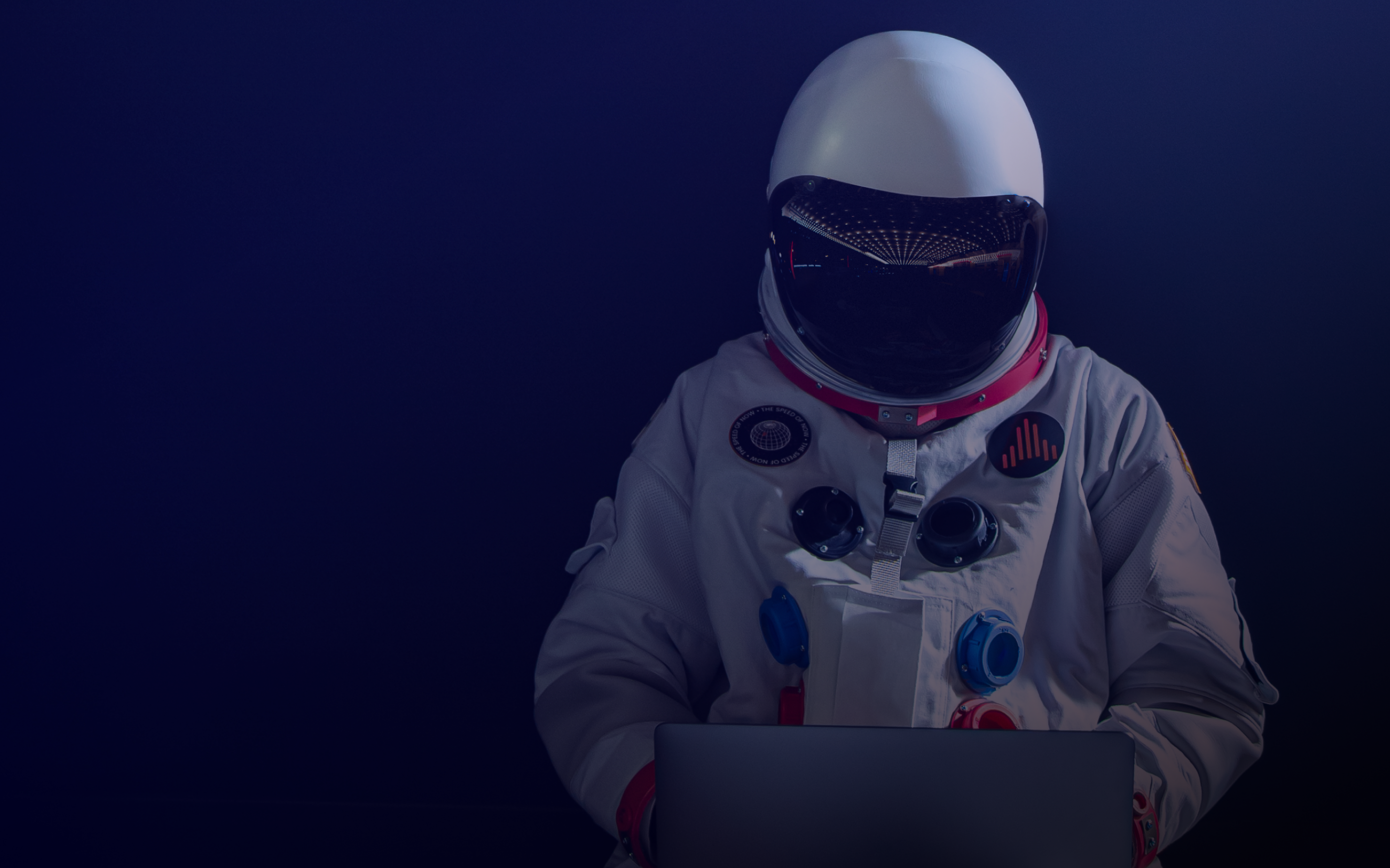 An astronaut working on a laptop.
