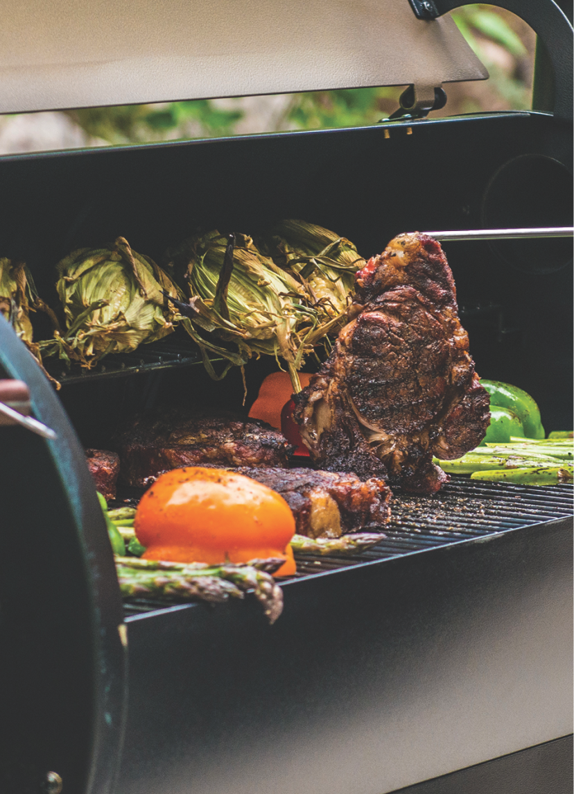 Steaks and vegetables on a grill.